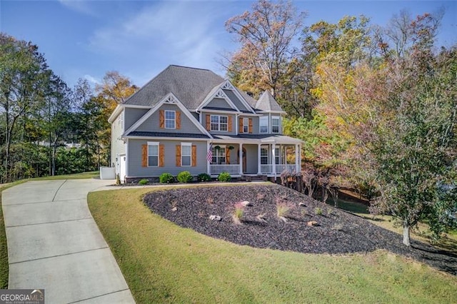 view of front facade with a porch, concrete driveway, and a front lawn