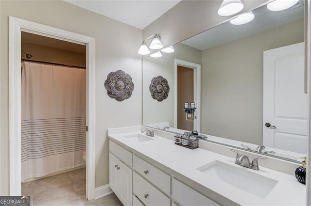 bathroom featuring double vanity, curtained shower, and a sink