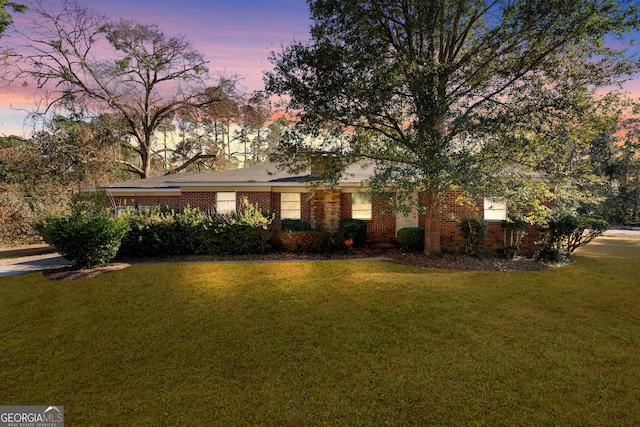 view of front of home featuring brick siding and a front yard