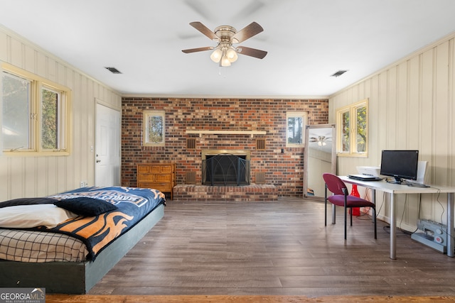 interior space featuring ceiling fan, visible vents, a fireplace, and wood finished floors