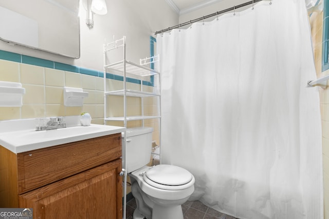 bathroom featuring toilet, vanity, tile walls, ornamental molding, and tile patterned floors