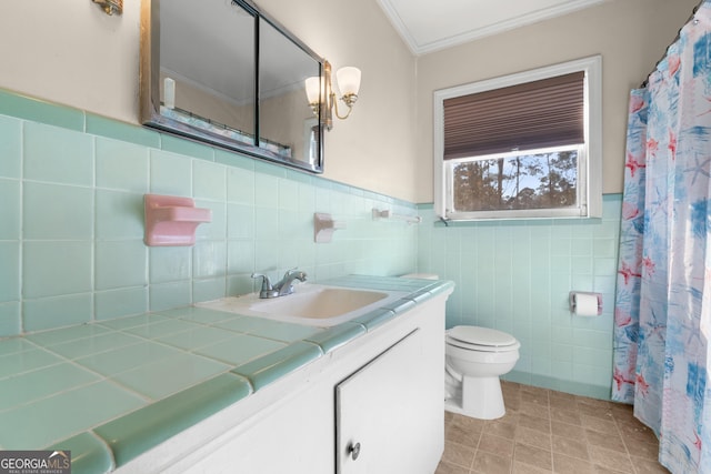 full bath featuring a wainscoted wall, crown molding, toilet, vanity, and tile patterned flooring