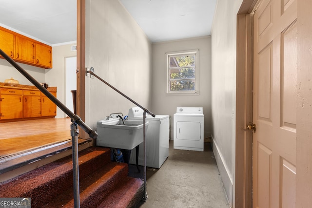 laundry room featuring crown molding, a sink, and independent washer and dryer