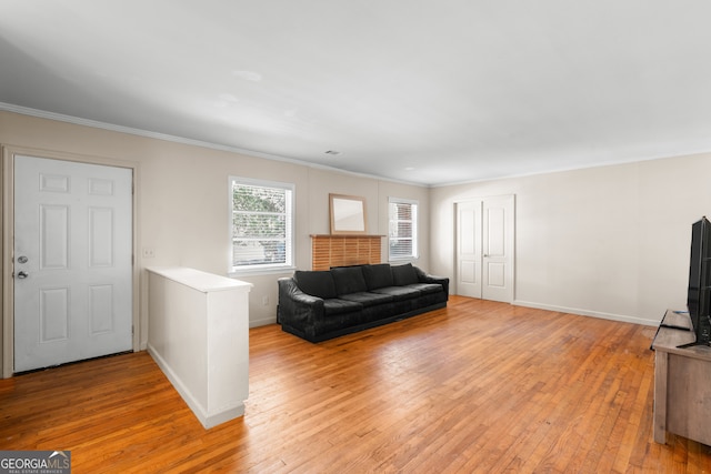 living room with light wood-type flooring, baseboards, and ornamental molding