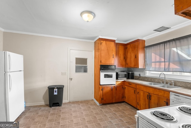 kitchen featuring ornamental molding, white appliances, a sink, and brown cabinets