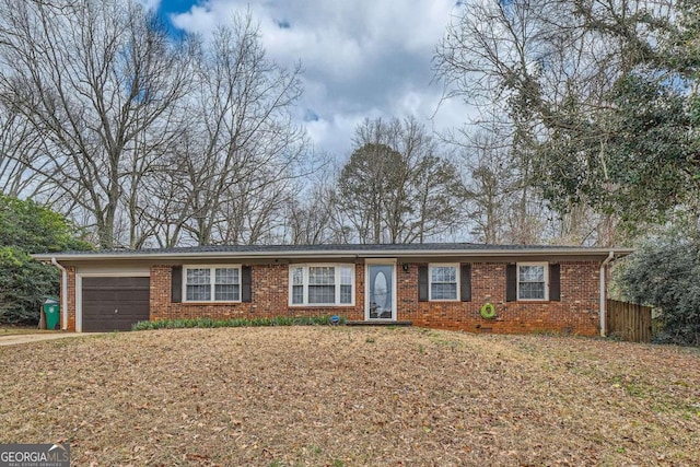 ranch-style home with a garage, brick siding, and driveway