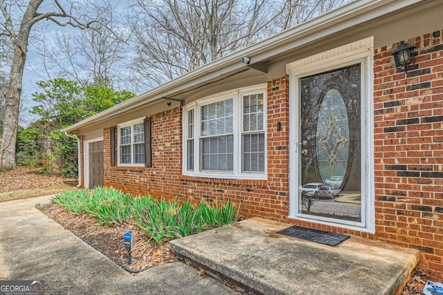 entrance to property featuring brick siding