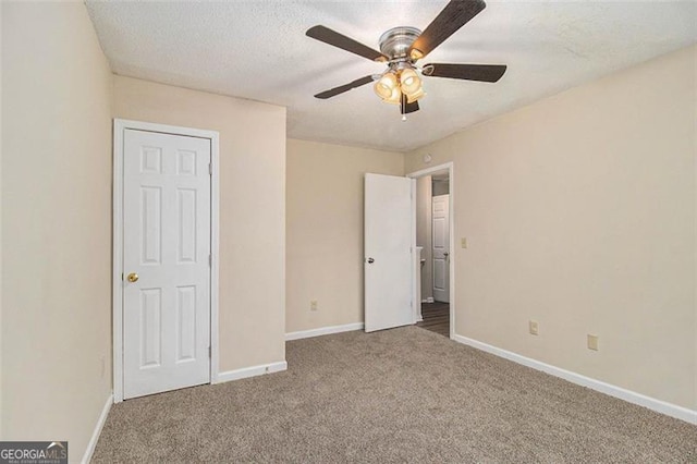 unfurnished bedroom featuring carpet floors, a textured ceiling, and baseboards