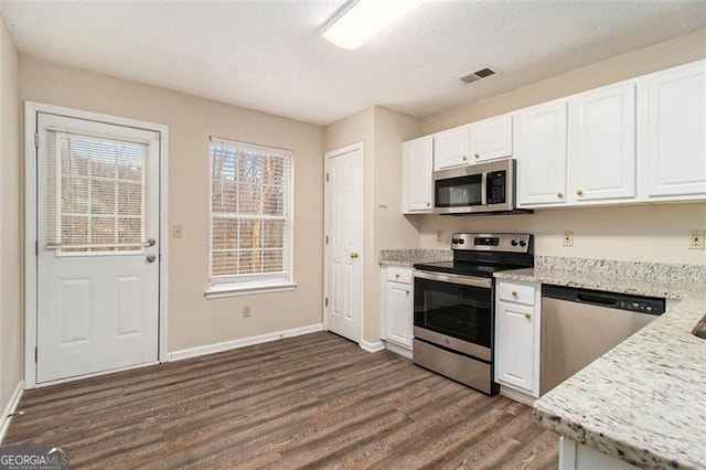 kitchen featuring a textured ceiling, visible vents, white cabinetry, appliances with stainless steel finishes, and dark wood finished floors