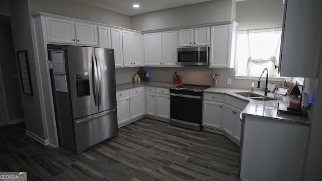 kitchen with white cabinetry, appliances with stainless steel finishes, dark wood finished floors, and a sink