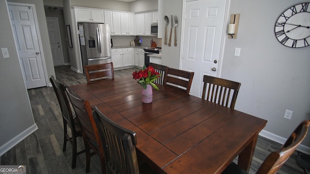 dining area with dark wood-style flooring and baseboards