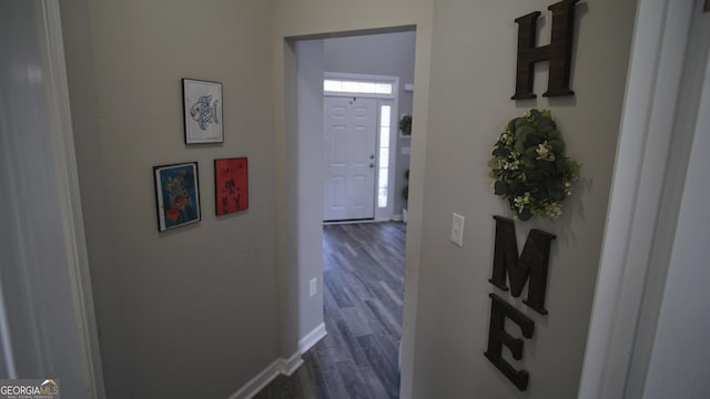 hall with dark wood-type flooring and baseboards