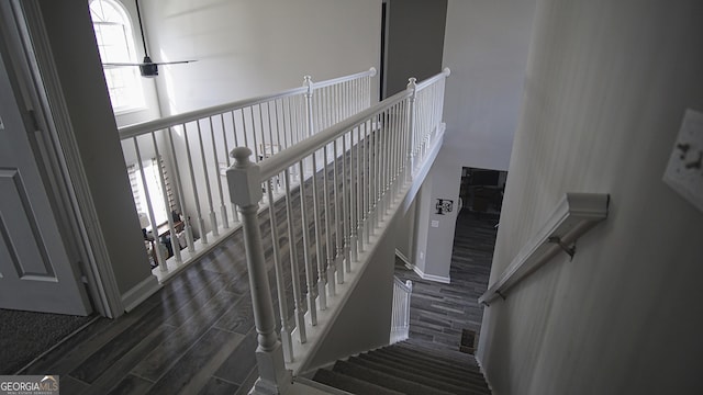 staircase with a high ceiling and wood finish floors