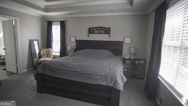 bedroom featuring baseboards, visible vents, a raised ceiling, ornamental molding, and carpet flooring