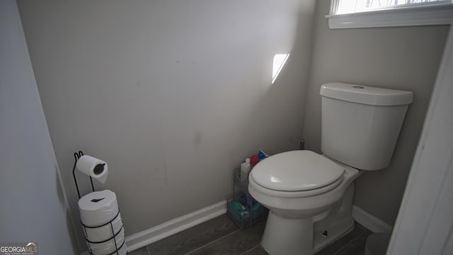 bathroom featuring baseboards, toilet, and wood finished floors