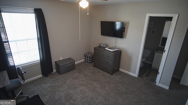 carpeted bedroom featuring ensuite bathroom and baseboards