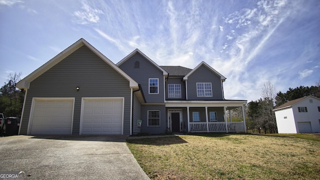 traditional home with covered porch, driveway, a front lawn, and an attached garage