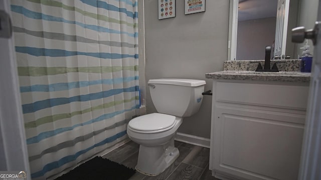 full bath with curtained shower, toilet, wood tiled floor, vanity, and baseboards