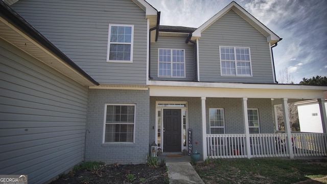 view of front of property with a porch and brick siding