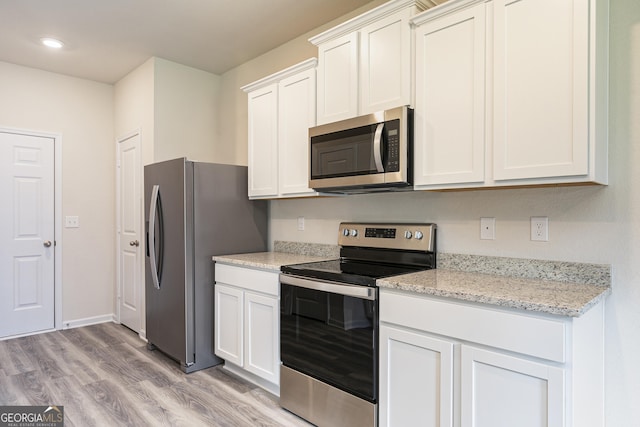 kitchen featuring light stone counters, recessed lighting, appliances with stainless steel finishes, white cabinets, and light wood-type flooring