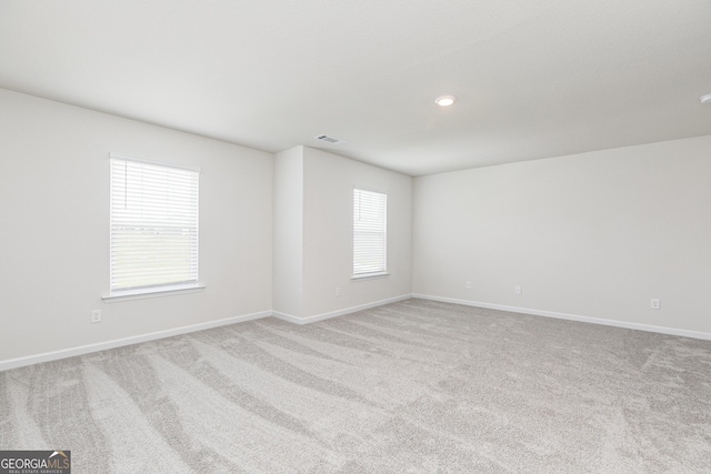 carpeted empty room with visible vents and baseboards