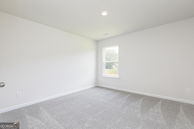 unfurnished room with carpet, visible vents, baseboards, and recessed lighting