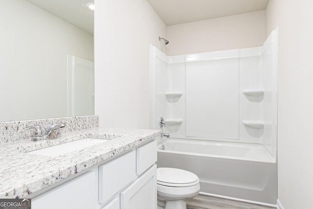 full bath featuring vanity, shower / tub combination, wood finished floors, and toilet