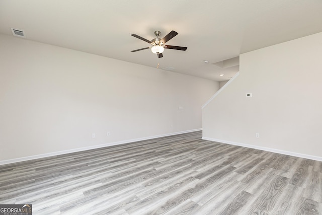 unfurnished room featuring baseboards, visible vents, ceiling fan, and light wood finished floors