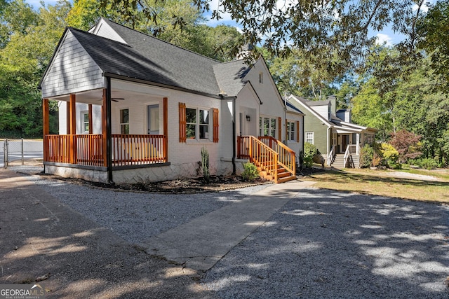 view of front of home with roof with shingles, ceiling fan, and brick siding