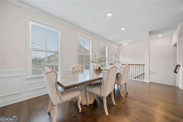 dining area featuring dark wood-style floors, a wainscoted wall, ornamental molding, a decorative wall, and recessed lighting