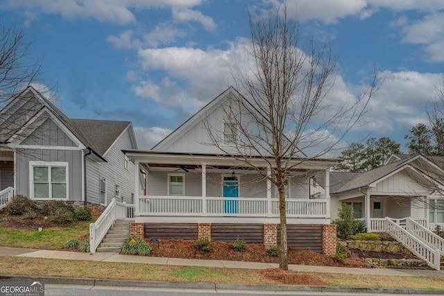 view of front facade featuring ceiling fan, a porch, stairway, and board and batten siding