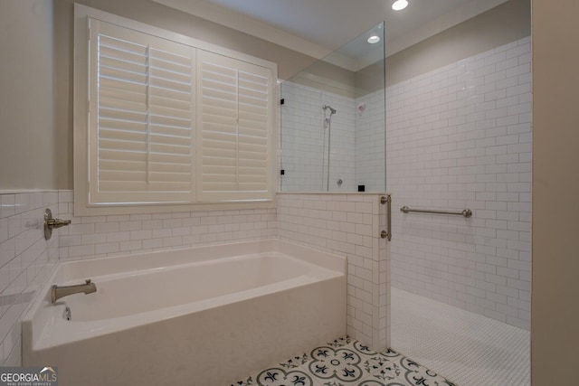 full bathroom featuring tile walls, a tile shower, a bath, and tile patterned floors