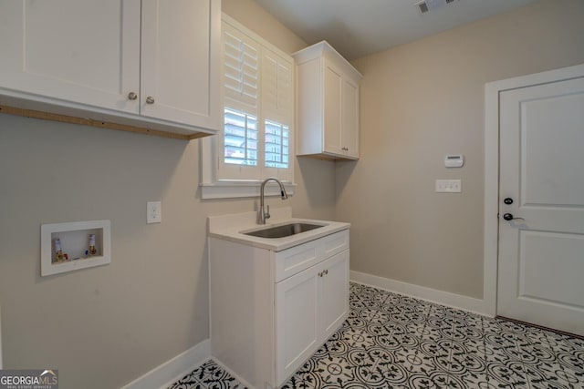 washroom featuring washer hookup, cabinet space, visible vents, a sink, and baseboards