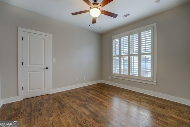 spare room with a ceiling fan, baseboards, visible vents, and dark wood-style flooring