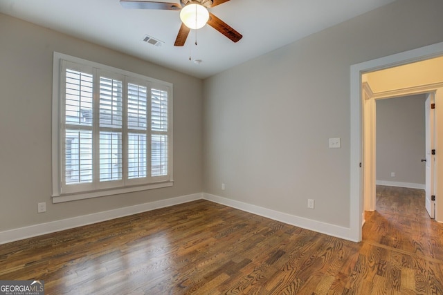 spare room with baseboards, visible vents, ceiling fan, and wood finished floors