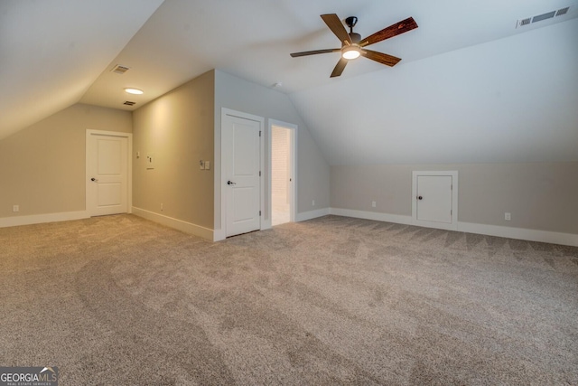 additional living space with visible vents, baseboards, ceiling fan, carpet, and vaulted ceiling