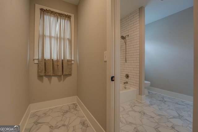 bathroom with marble finish floor, tub / shower combination, toilet, and baseboards