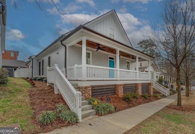 view of front of house featuring a ceiling fan, a porch, stairs, a front lawn, and board and batten siding