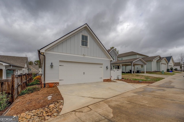 view of front of property featuring board and batten siding, driveway, and fence