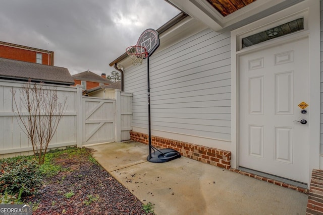 view of exterior entry with fence and a gate