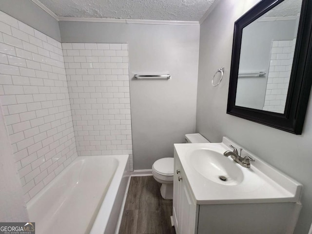 bathroom featuring toilet, ornamental molding, wood finished floors, a textured ceiling, and vanity