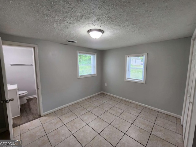 unfurnished bedroom with multiple windows, visible vents, and baseboards