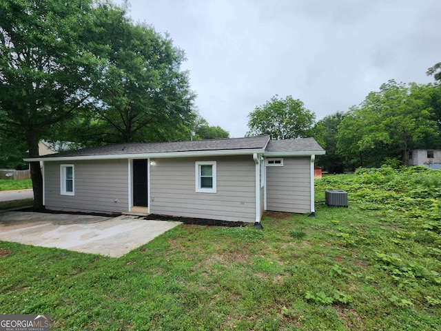 back of property with a yard, a patio, and central air condition unit