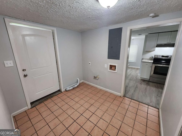 clothes washing area featuring washer hookup, a textured ceiling, laundry area, electric panel, and baseboards