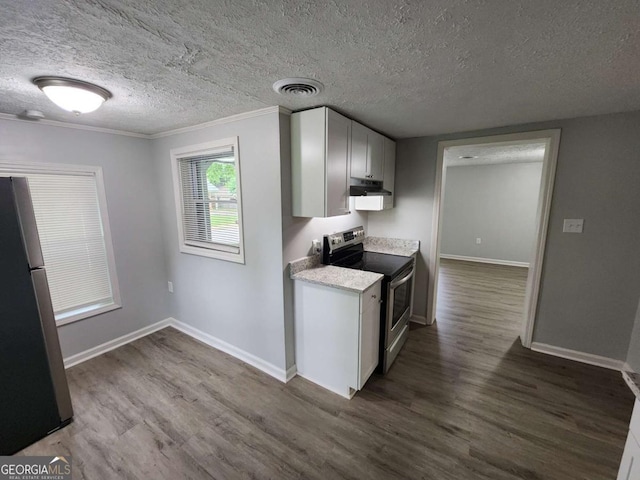 kitchen featuring dark wood-style flooring, visible vents, light countertops, freestanding refrigerator, and stainless steel electric range oven