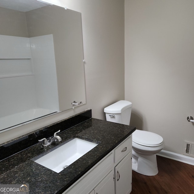 bathroom featuring visible vents, toilet, wood finished floors, baseboards, and vanity