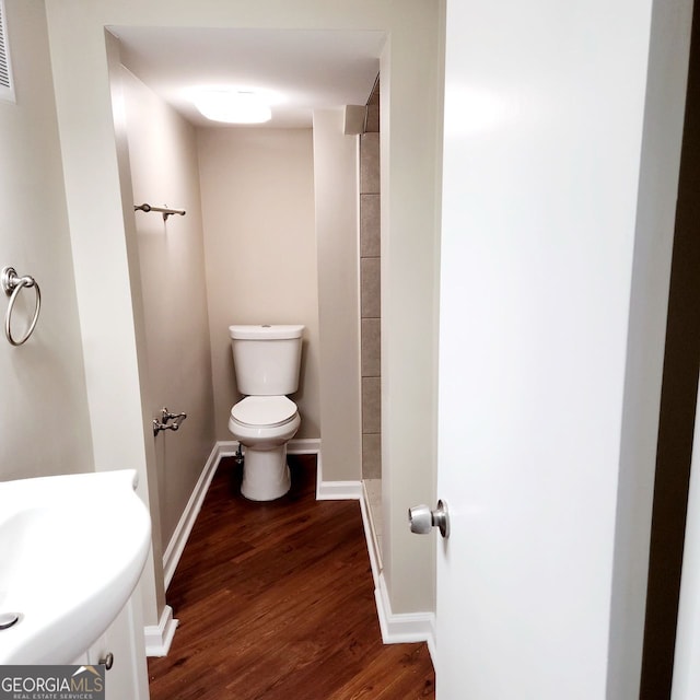 full bath featuring a sink, toilet, baseboards, and wood finished floors