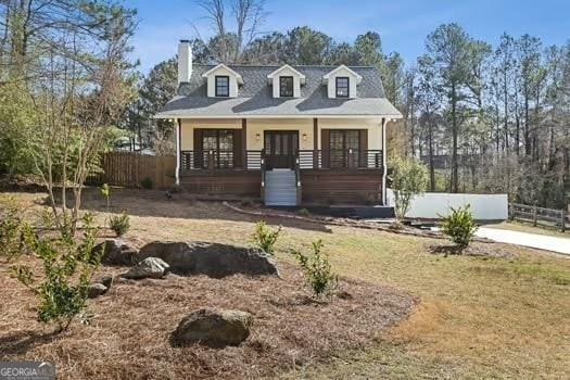 view of front of property with a porch and fence