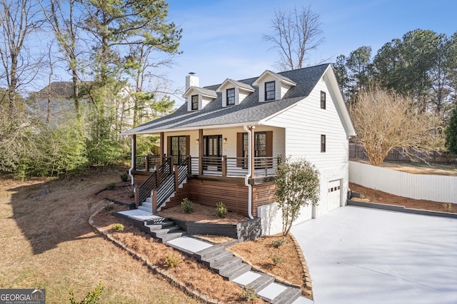 view of front of property with driveway, roof with shingles, an attached garage, stairs, and a porch