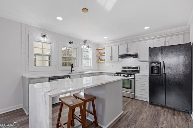 kitchen with backsplash, appliances with stainless steel finishes, dark wood-type flooring, a sink, and under cabinet range hood